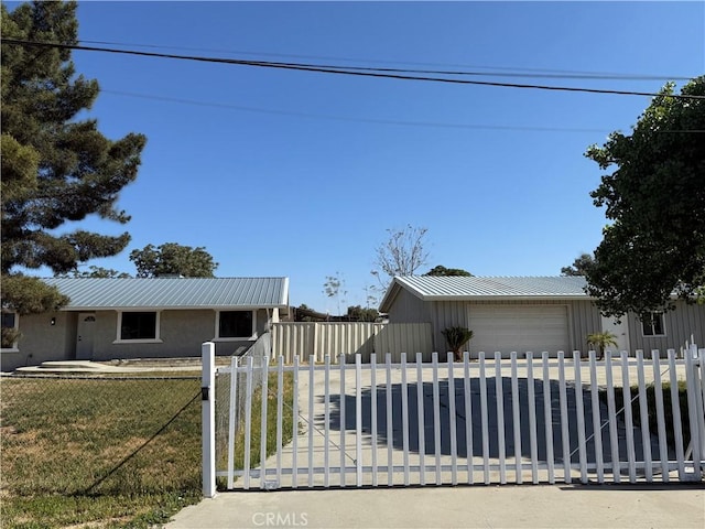 ranch-style house with board and batten siding, a fenced front yard, metal roof, and a front yard