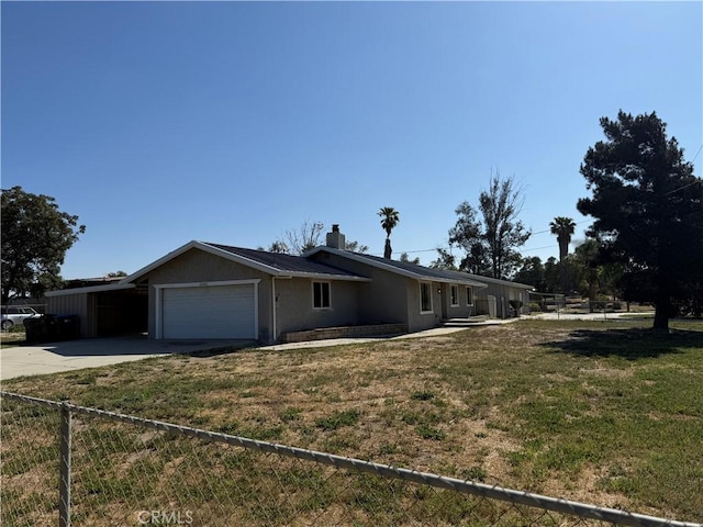 ranch-style house featuring a chimney, a garage, fence, a front lawn, and concrete driveway