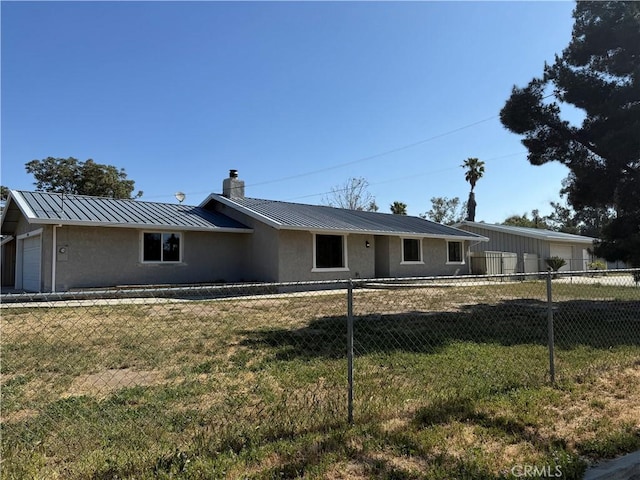 ranch-style house with stucco siding, fence, a chimney, and a standing seam roof