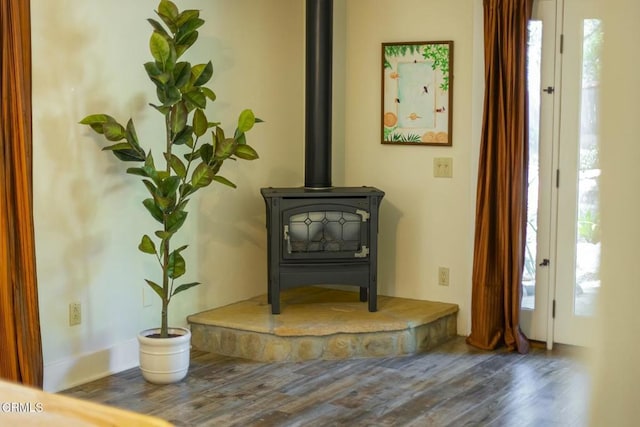 interior details with wood finished floors and a wood stove