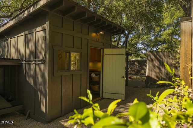 view of outbuilding featuring fence and an outbuilding