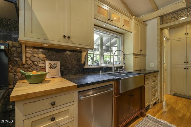 kitchen featuring a sink, wood counters, lofted ceiling with beams, dishwasher, and light wood-style flooring
