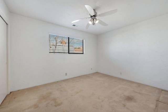 unfurnished room featuring light colored carpet and a ceiling fan