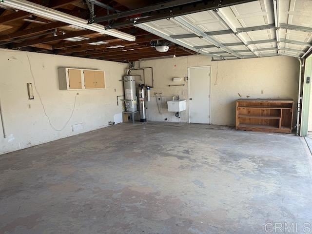 garage with strapped water heater and a sink