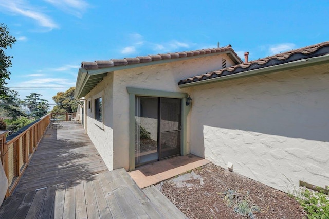 view of property exterior with stucco siding and a deck