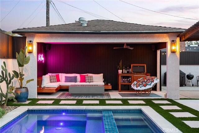 back of house featuring an outdoor hangout area, roof with shingles, an outdoor pool, and ceiling fan