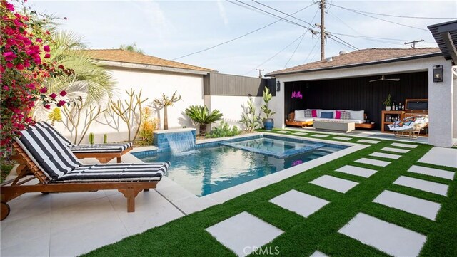 view of pool with a yard, outdoor lounge area, a patio area, and a pool with connected hot tub