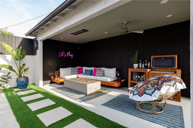 view of patio with an outdoor living space with a fire pit and a ceiling fan