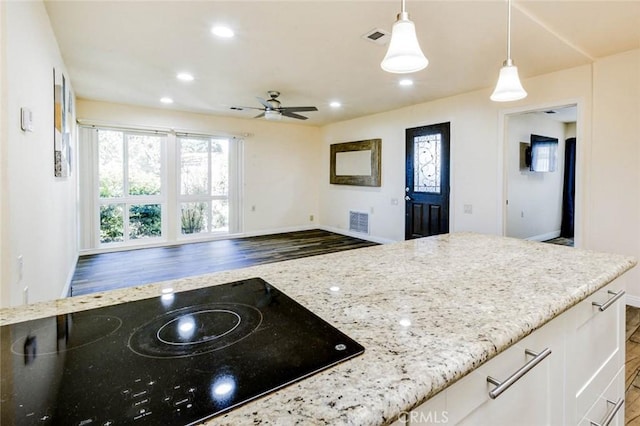 2119 Via Puerta Unit U, Laguna Woods, CA 92637 - kitchen with black electric cooktop, baseboards, visible vents, and light stone counters