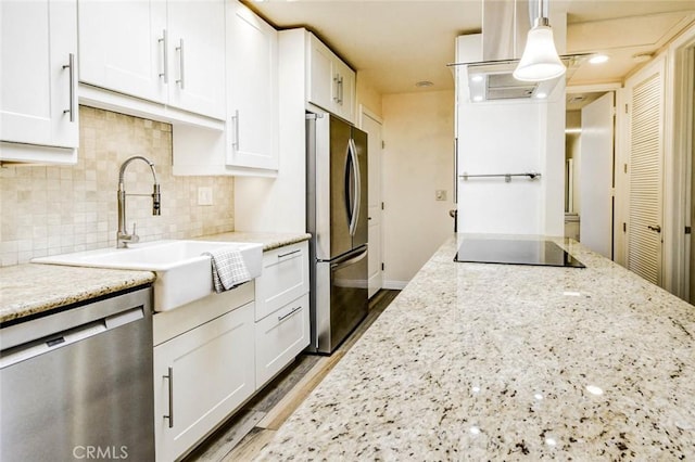 2119 Via Puerta Unit U, Laguna Woods, CA 92637 - kitchen with a sink, backsplash, white cabinetry, light stone countertops, and appliances with stainless steel finishes