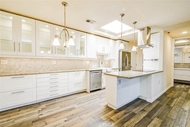 2119 Via Puerta Unit U, Laguna Woods, CA 92637 - kitchen featuring white cabinetry, wood finished floors, stainless steel appliances, and extractor fan