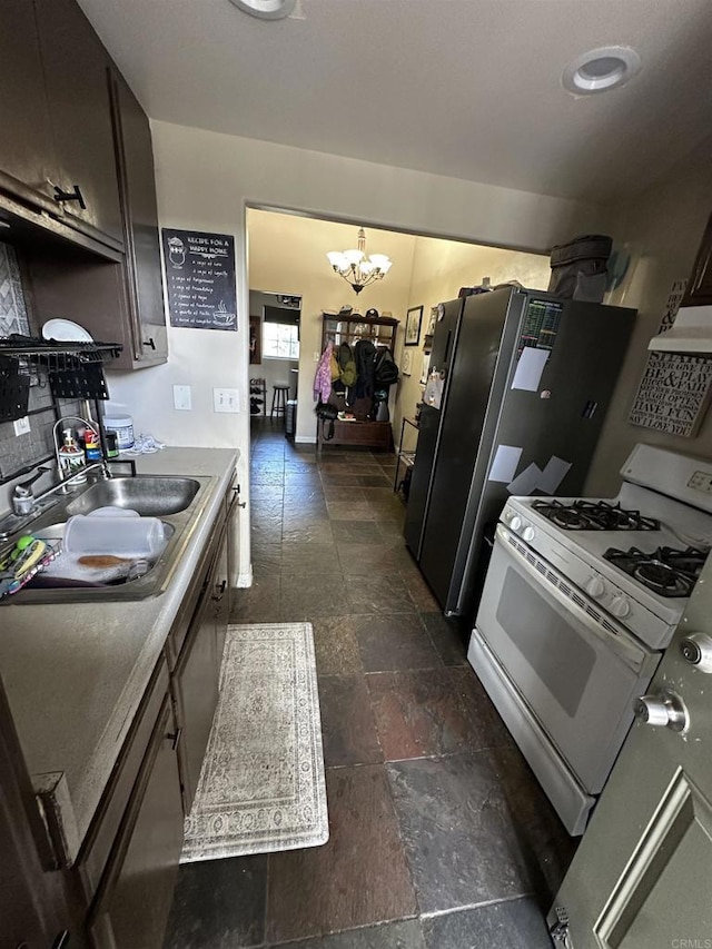 18326 Brightman Ave, Lake Elsinore, CA 92530 - kitchen with an inviting chandelier, stone tile floors, white range with gas cooktop, a sink, and dishwasher