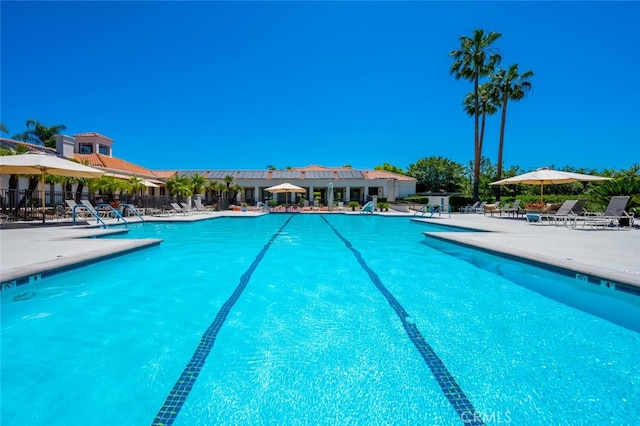 pool featuring fence and a patio area