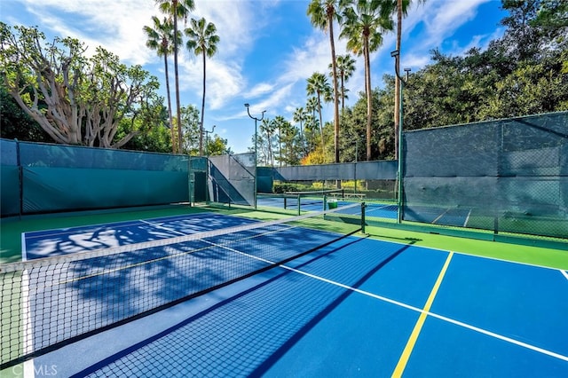 view of tennis court featuring fence