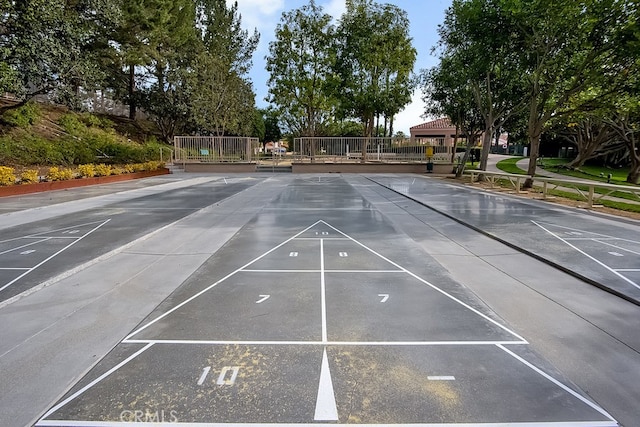 view of community featuring uncovered parking and shuffleboard