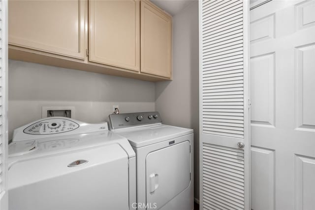 laundry area with separate washer and dryer and cabinet space