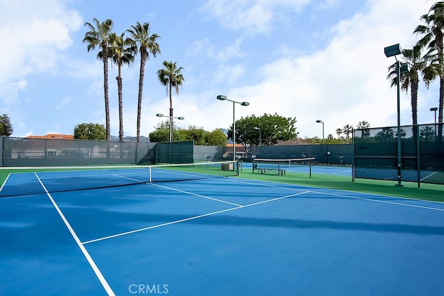 view of tennis court featuring fence