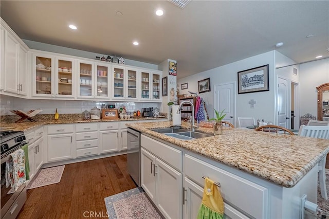 718 Marybelle Dr, Merced, CA 95348 - kitchen with white cabinets, a kitchen island with sink, dark wood-style floors, a sink, and appliances with stainless steel finishes