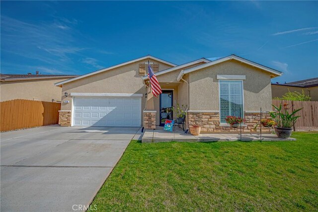 718 Marybelle Dr, Merced, CA 95348 - ranch-style home with stone siding, an attached garage, fence, and stucco siding