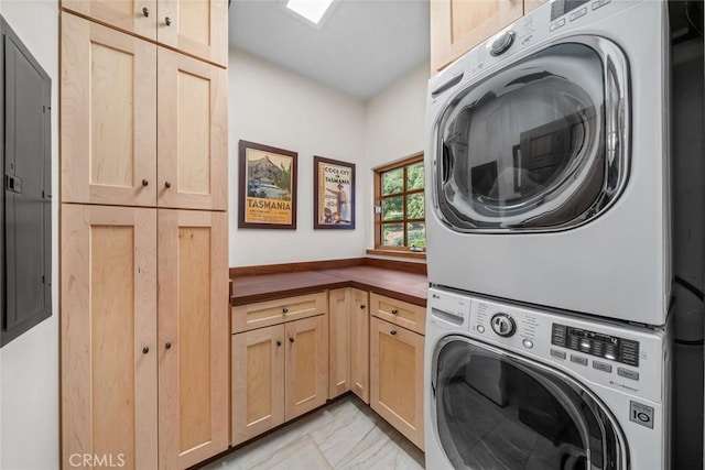 washroom with cabinet space and stacked washing maching and dryer