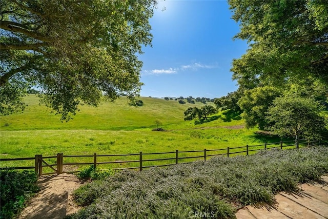 view of yard featuring fence and a rural view