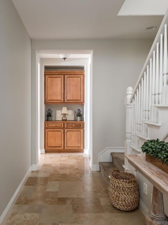 7076 Heron Cir, Carlsbad, CA 92011 - hallway with stairway, baseboards, and stone finish floors