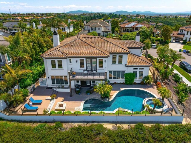 7076 Heron Cir, Carlsbad, CA 92011 - back of property featuring a chimney, a pool with connected hot tub, a tile roof, and a fenced backyard