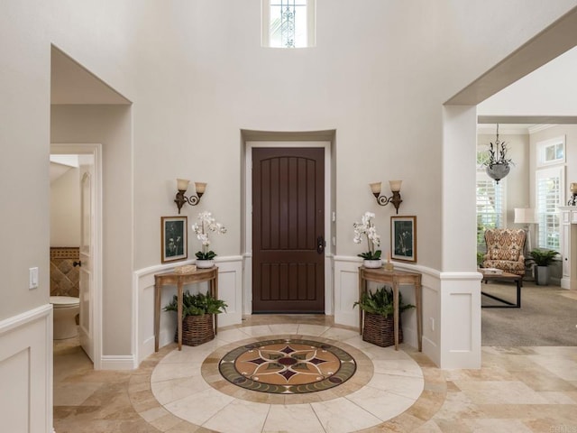 7076 Heron Cir, Carlsbad, CA 92011 - entryway with a high ceiling, wainscoting, a decorative wall, and inlaid floor details