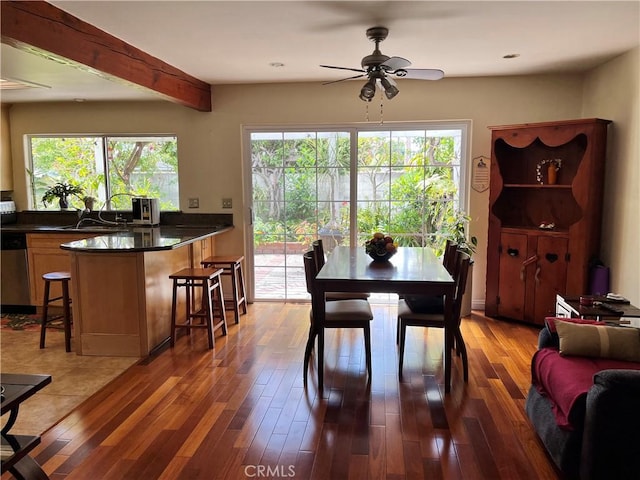 dining room featuring wood finished floors, a ceiling fan, and beamed ceiling