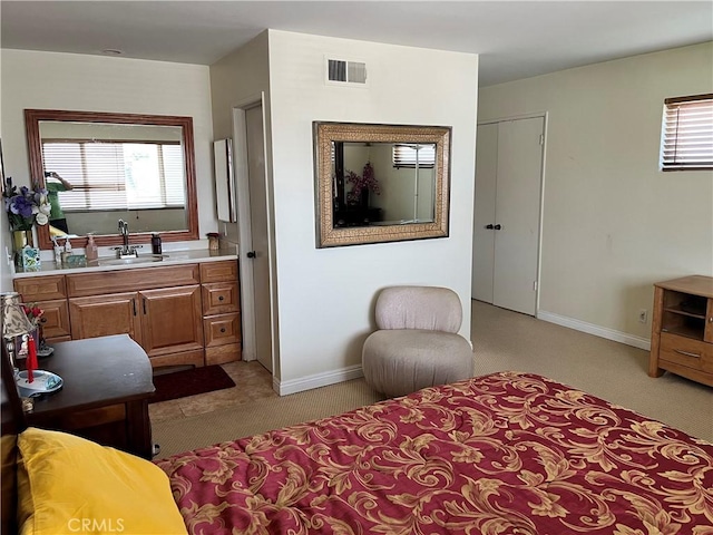 bedroom with a sink, multiple windows, light carpet, and visible vents