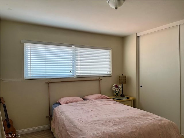 bedroom featuring baseboards and a closet