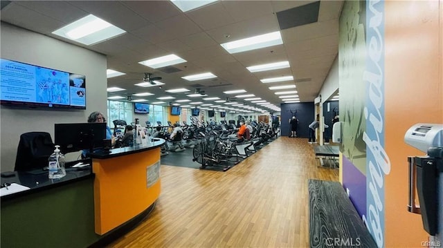 gym with wood finished floors and a drop ceiling