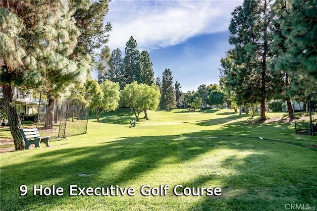 view of community with view of golf course and a yard