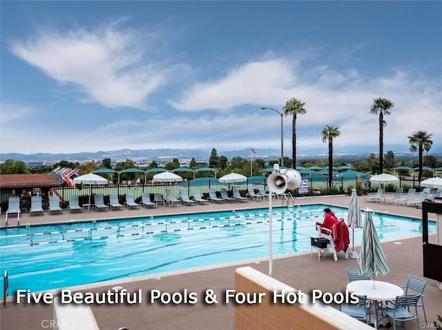 pool with a patio area and fence
