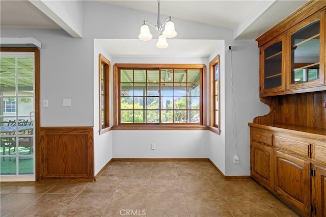 unfurnished dining area with a chandelier, lofted ceiling, and light tile patterned floors