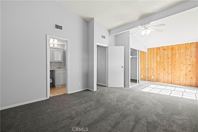 unfurnished bedroom featuring baseboards, visible vents, carpet flooring, and high vaulted ceiling