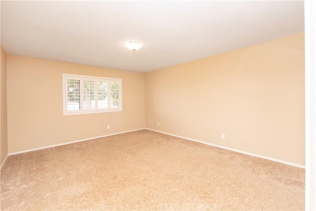 carpeted spare room with baseboards