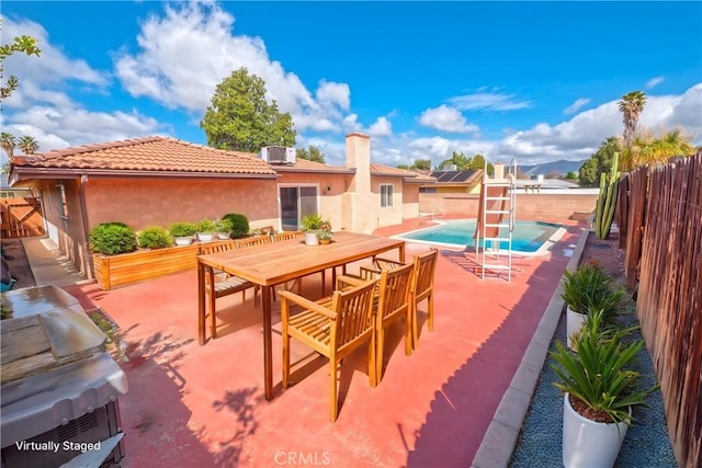 view of patio / terrace with a fenced backyard, a fenced in pool, and outdoor dining area