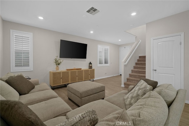 living room with recessed lighting, wood finished floors, visible vents, and stairway