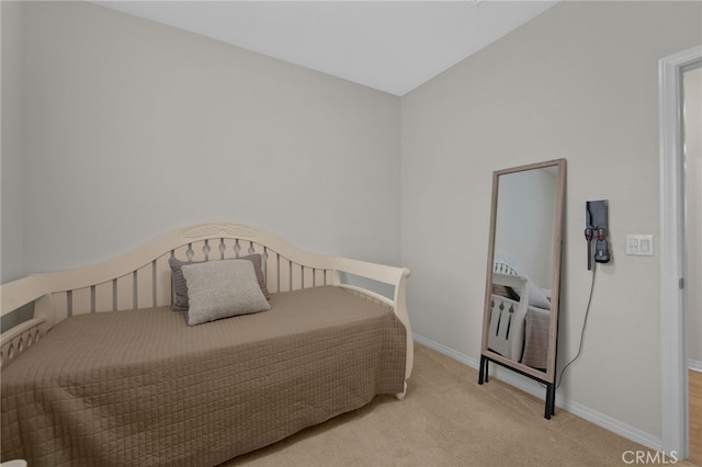 bedroom with baseboards and light colored carpet