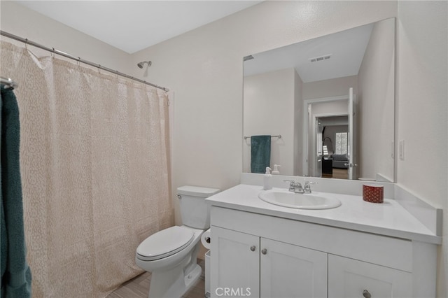 full bathroom featuring wood finished floors, visible vents, toilet, and vanity
