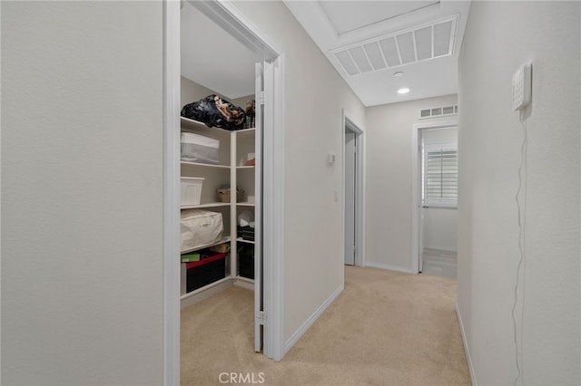 hall featuring baseboards, visible vents, and carpet floors