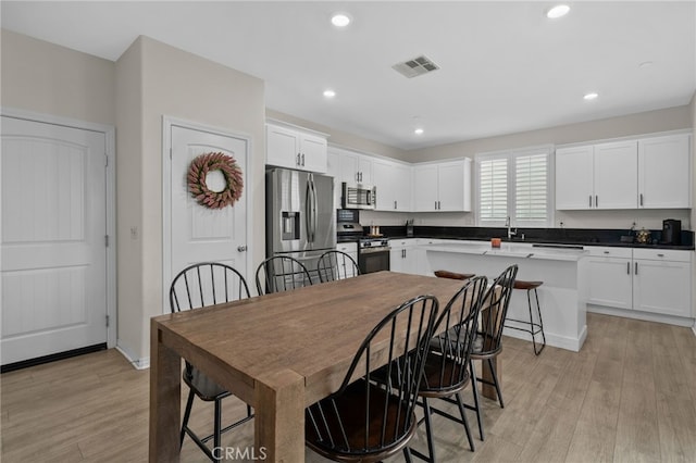 dining area with baseboards, light wood-style floors, visible vents, and recessed lighting