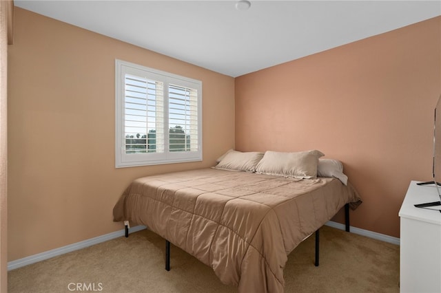 bedroom featuring light carpet and baseboards