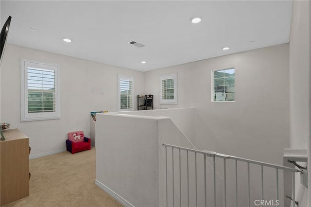 corridor with an upstairs landing, light colored carpet, baseboards, visible vents, and recessed lighting