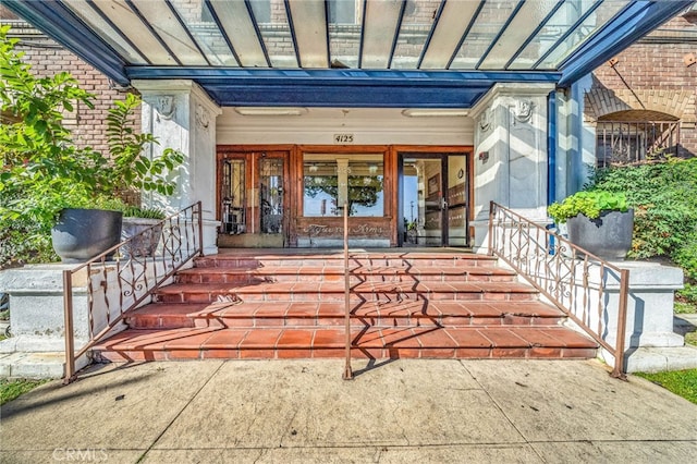 entrance to property featuring brick siding and covered porch