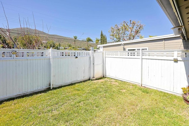 view of yard featuring a gate, fence, and a mountain view