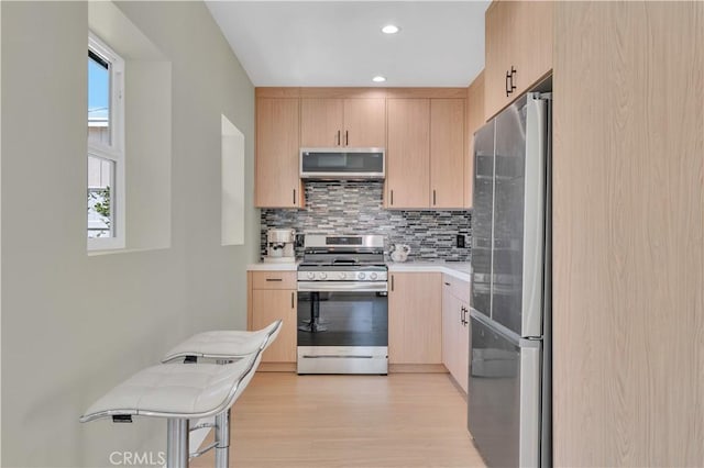 13301332 N Lincoln St, Burbank, CA 91506 - kitchen featuring stainless steel appliances, light wood-style flooring, light countertops, backsplash, and light brown cabinets
