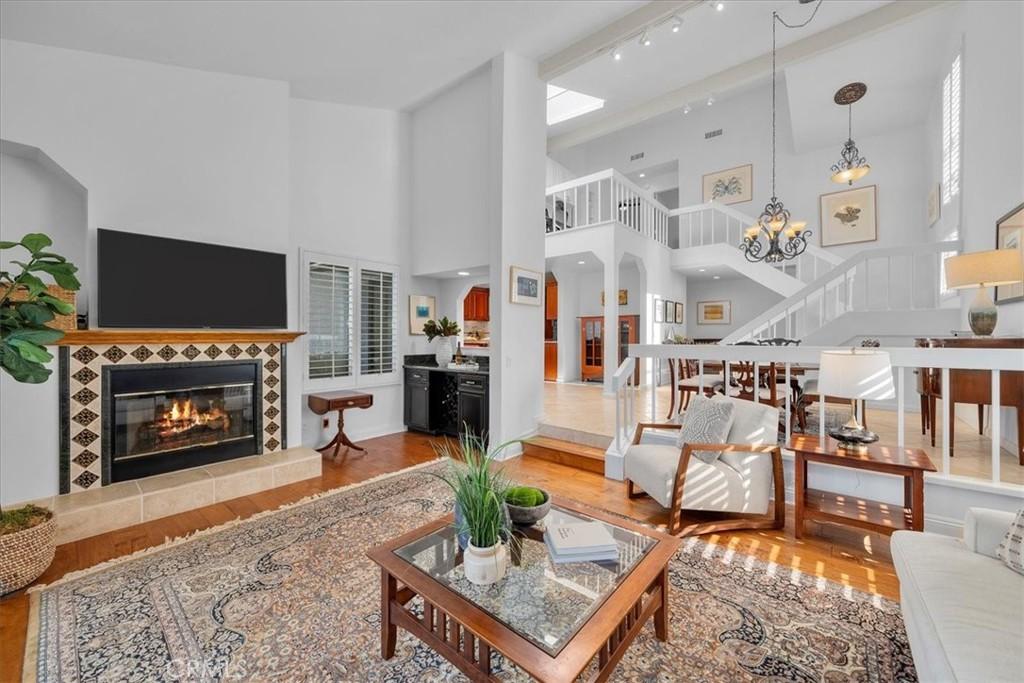 1633 Michael Ln, Pacific Palisades, CA 90272 - living area with stairs, a towering ceiling, wood finished floors, and a fireplace