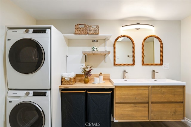 laundry area featuring dark wood-style floors, stacked washing maching and dryer, and laundry area